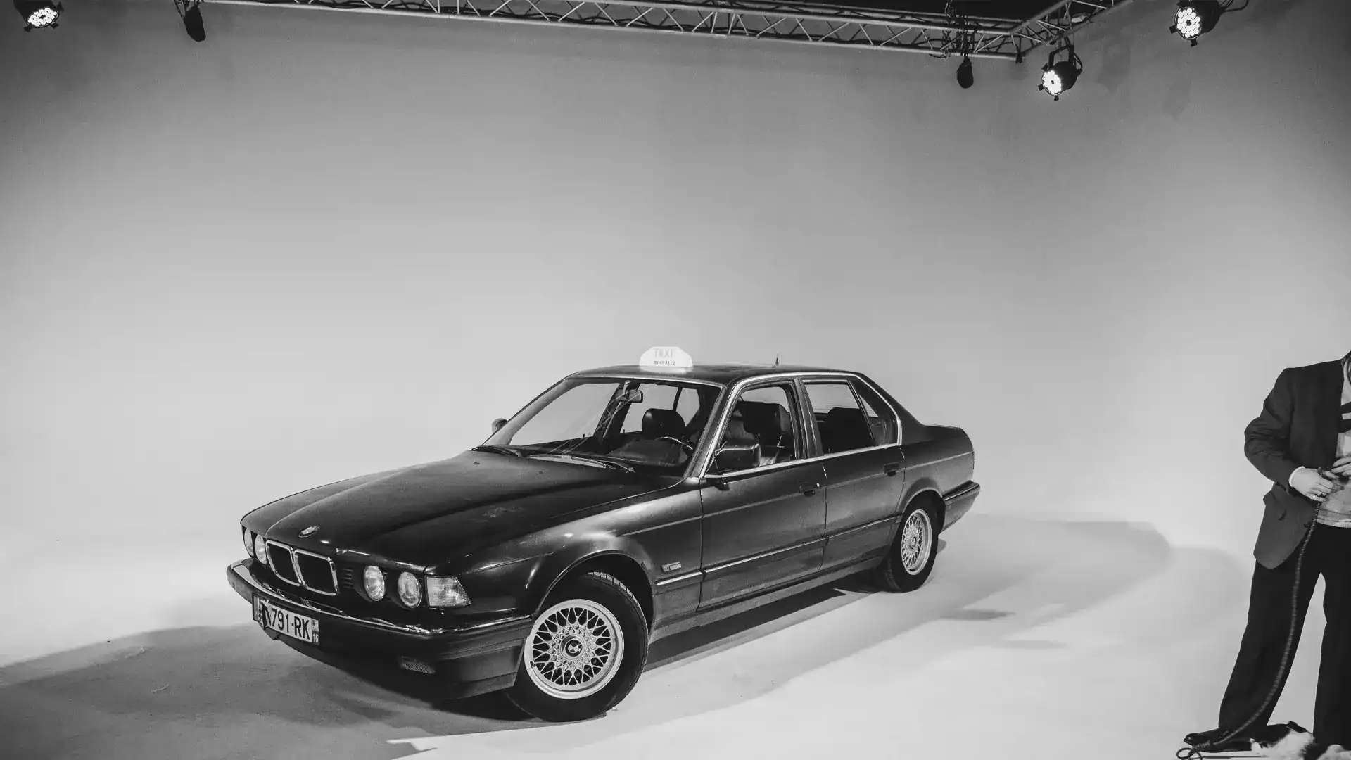 Backstage du tournage d'un clip avec une BMW E32 dans un studio vidéo sur fond blanc